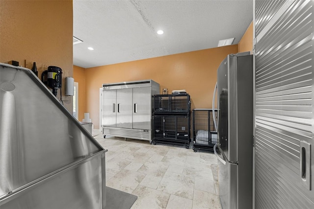 misc room with recessed lighting, a textured ceiling, and stone finish floor