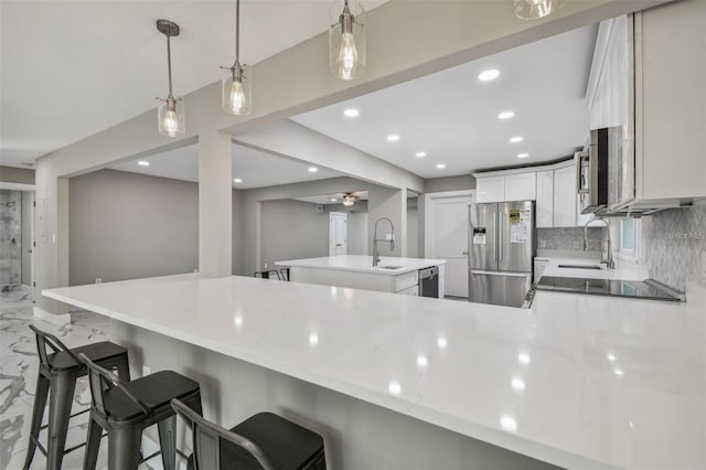 2042 Craft Ln, Sarasota, FL 34239 - kitchen with marble finish floor, a peninsula, tasteful backsplash, a sink, and stainless steel appliances