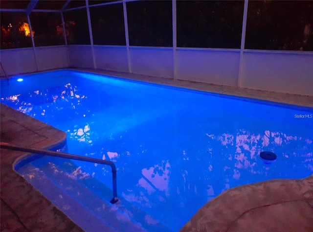 2042 Craft Ln, Sarasota, FL 34239 - pool at night featuring glass enclosure and an outdoor pool