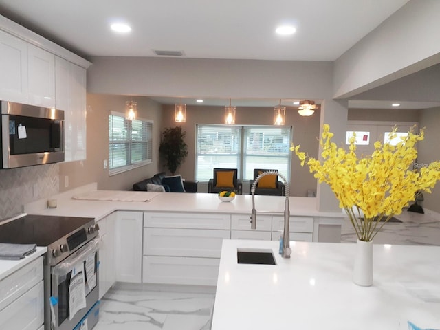 2042 Craft Ln, Sarasota, FL 34239 - kitchen with a sink, light countertops, marble finish floor, stainless steel appliances, and recessed lighting