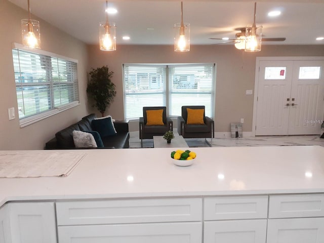 2042 Craft Ln, Sarasota, FL 34239 - kitchen featuring light countertops, hanging light fixtures, white cabinets, and open floor plan