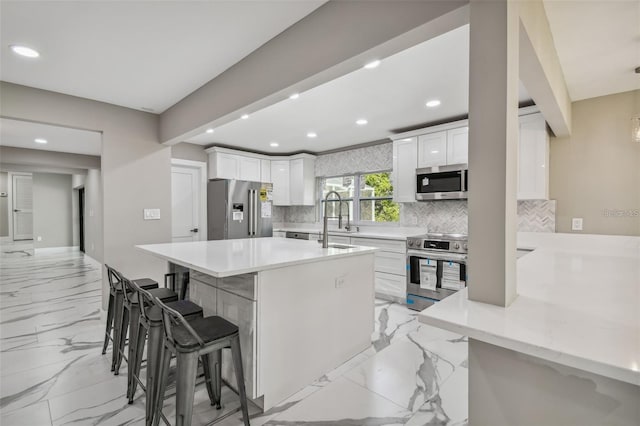 2042 Craft Ln, Sarasota, FL 34239 - kitchen featuring appliances with stainless steel finishes, marble finish floor, recessed lighting, a kitchen bar, and backsplash