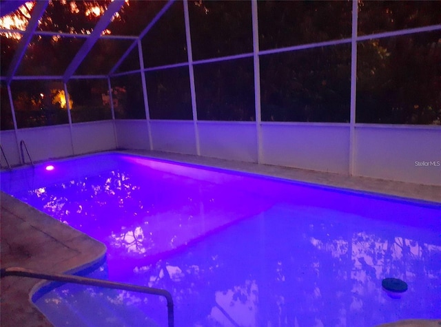 2042 Craft Ln, Sarasota, FL 34239 - pool at twilight featuring glass enclosure and an outdoor pool