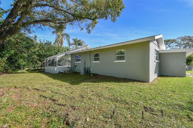 2042 Craft Ln, Sarasota, FL 34239 - rear view of house with central AC unit, stucco siding, and a yard
