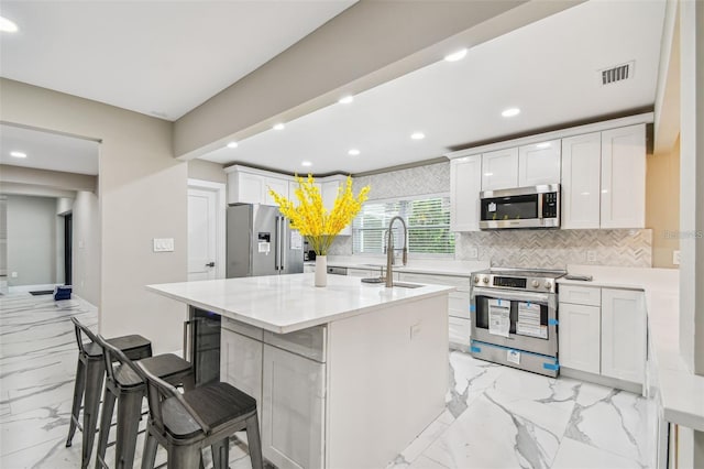 2042 Craft Ln, Sarasota, FL 34239 - kitchen with marble finish floor, a center island with sink, recessed lighting, a sink, and stainless steel appliances