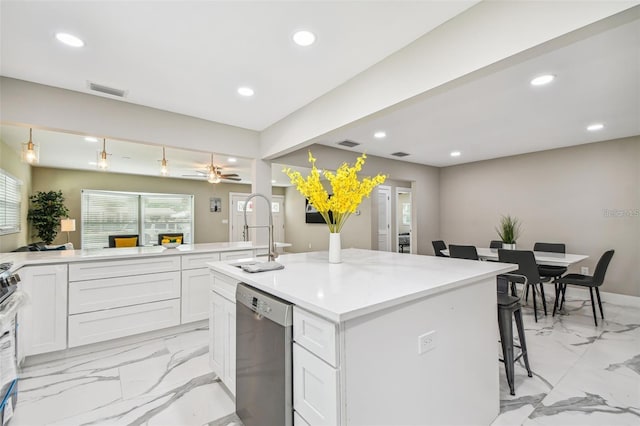 2042 Craft Ln, Sarasota, FL 34239 - kitchen featuring white cabinets, appliances with stainless steel finishes, a sink, marble finish floor, and a kitchen bar