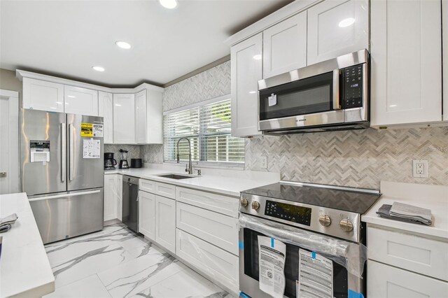 2042 Craft Ln, Sarasota, FL 34239 - kitchen with recessed lighting, light countertops, white cabinets, a sink, and appliances with stainless steel finishes