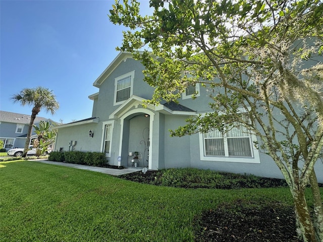traditional-style home with a front lawn and stucco siding