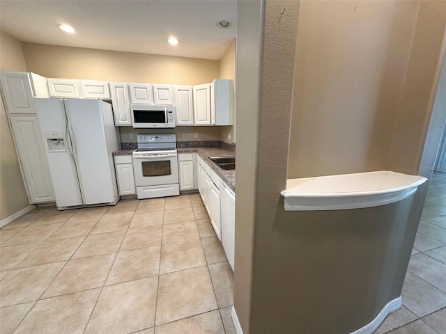 kitchen with white cabinetry, light tile patterned floors, a sink, recessed lighting, and white appliances
