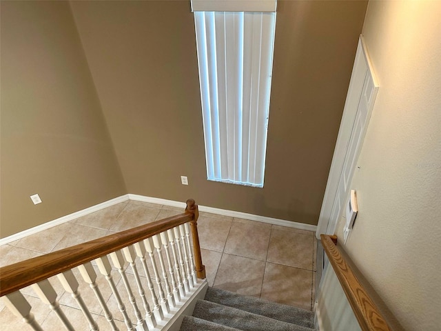 stairway featuring tile patterned flooring and baseboards