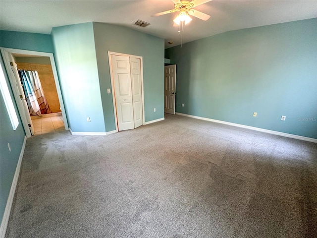 unfurnished bedroom with a ceiling fan, visible vents, baseboards, a closet, and carpet