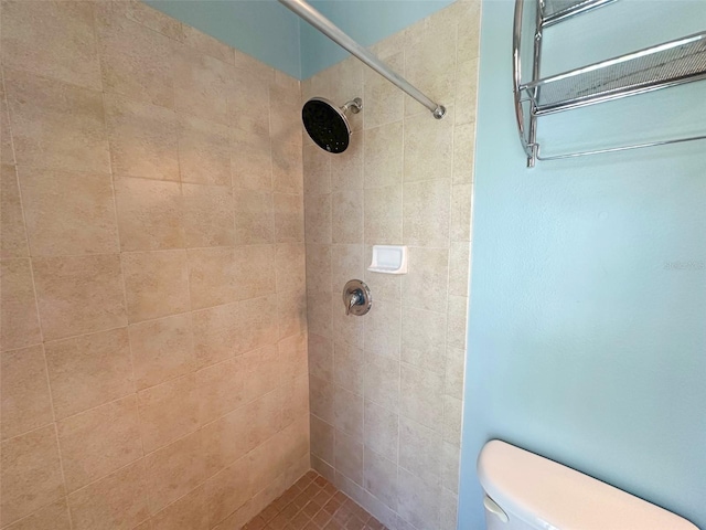 bathroom featuring toilet and a tile shower