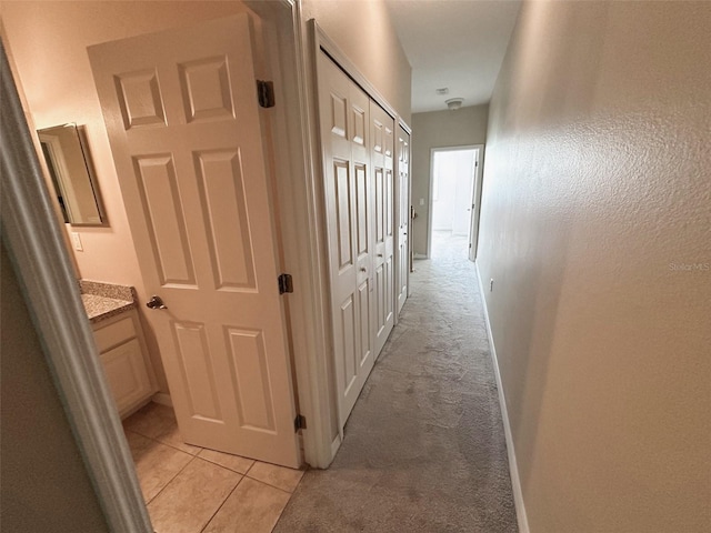 corridor featuring light colored carpet and light tile patterned floors