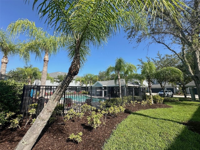 view of yard featuring fence and a community pool