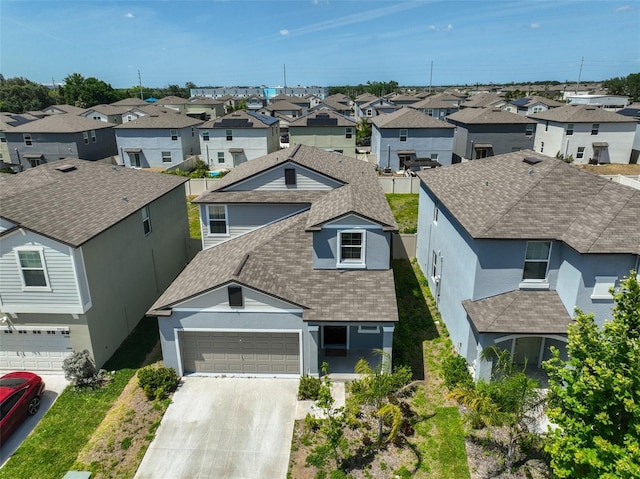 view of front of house featuring driveway, roof with shingles, a residential view, an attached garage, and stucco siding