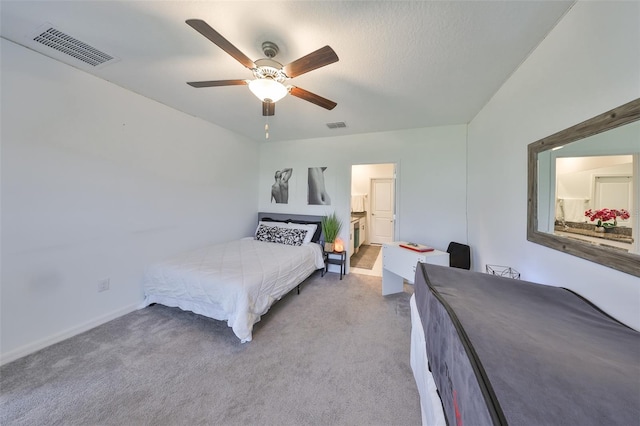 carpeted bedroom featuring visible vents, connected bathroom, baseboards, and ceiling fan