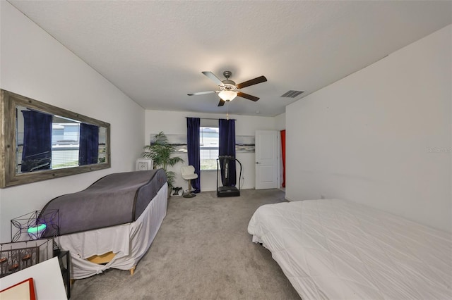 carpeted bedroom featuring a ceiling fan and visible vents