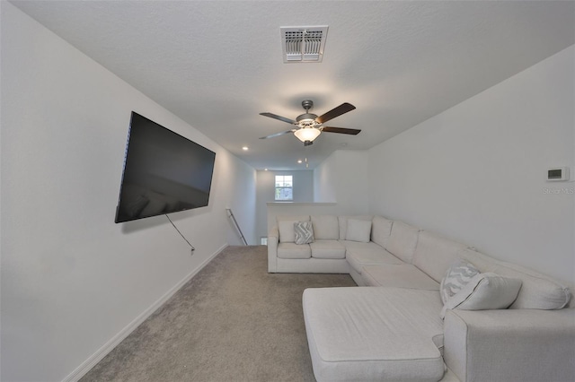 living room featuring baseboards, a ceiling fan, light colored carpet, and visible vents