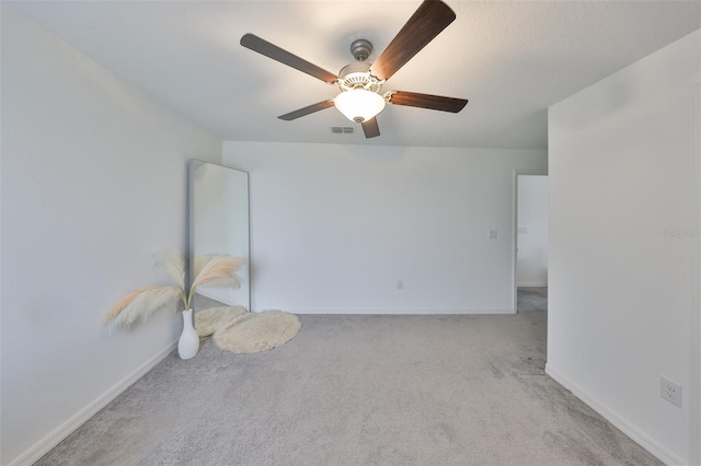 unfurnished room featuring visible vents, carpet flooring, baseboards, and a ceiling fan