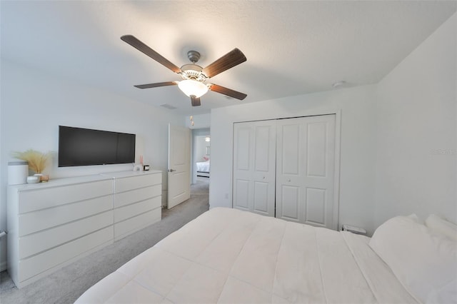 carpeted bedroom with a closet, a ceiling fan, and visible vents