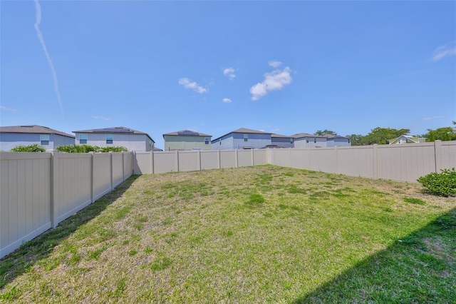 view of yard featuring a fenced backyard and a residential view