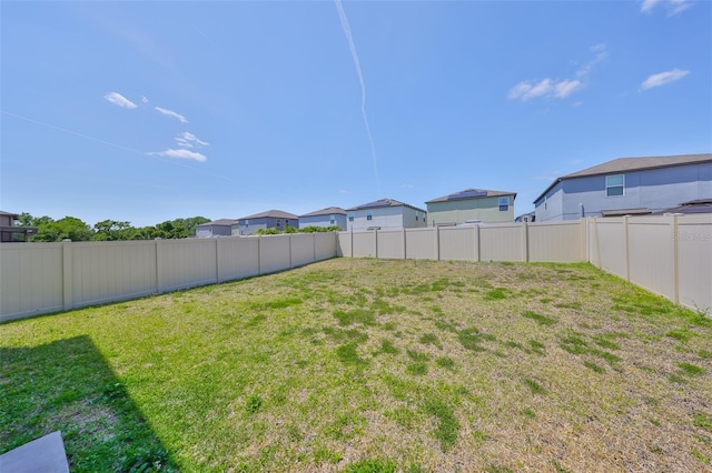 view of yard featuring a fenced backyard and a residential view