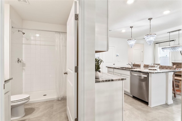 35780 Sunflower Hill Dr, Zephyrhills, FL 33541 - kitchen with white cabinetry, a sink, dark stone countertops, dishwasher, and decorative light fixtures