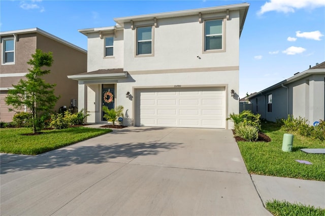 35780 Sunflower Hill Dr, Zephyrhills, FL 33541 - traditional home featuring a garage, a front lawn, stucco siding, and concrete driveway