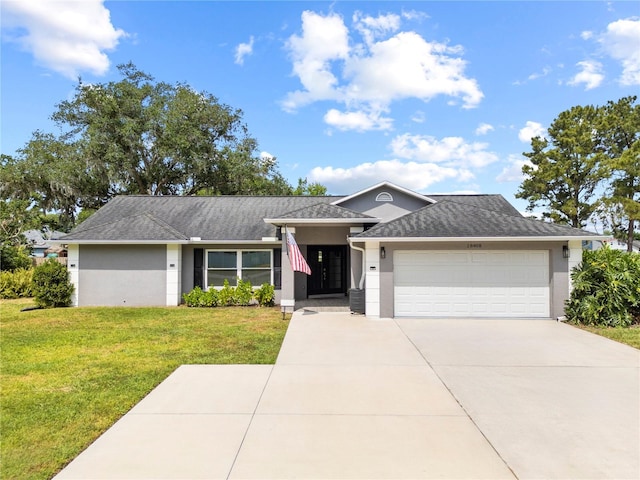 view of front of property featuring concrete driveway, stucco siding, a garage, and a front lawn