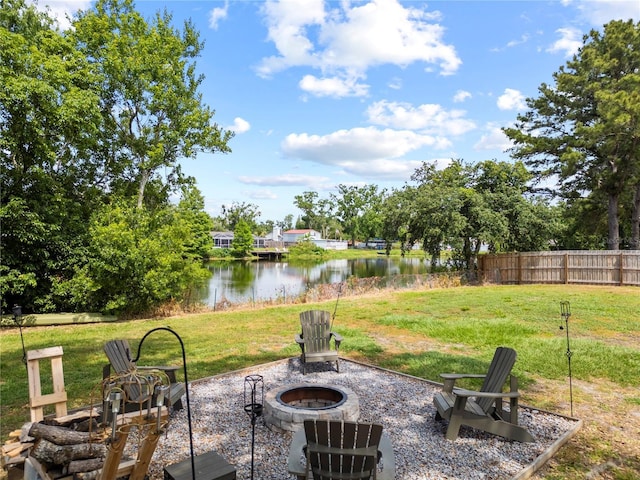 view of patio featuring fence, a water view, and a fire pit