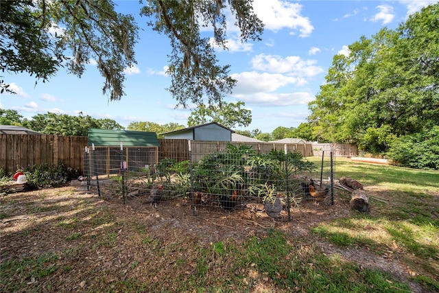 view of yard featuring exterior structure, a garden, an outdoor structure, and a fenced backyard