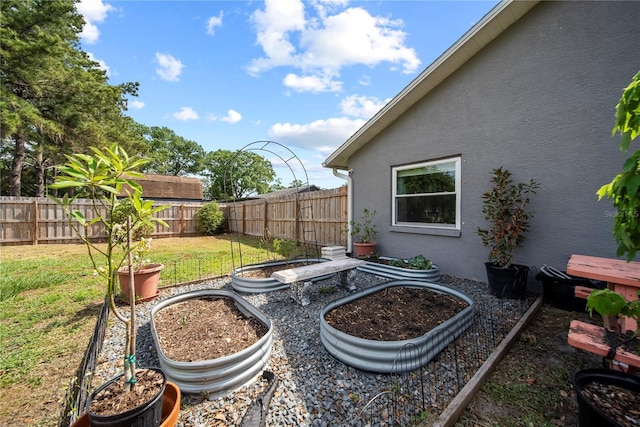 view of yard with a vegetable garden and a fenced backyard