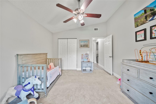 bedroom featuring a closet, light carpet, visible vents, baseboards, and vaulted ceiling