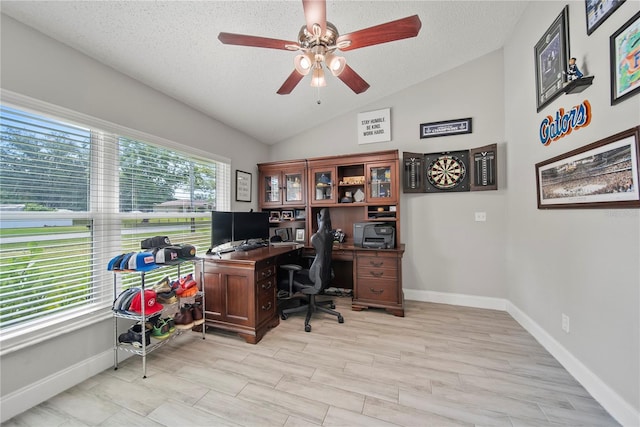 office space featuring vaulted ceiling, ceiling fan, a textured ceiling, and baseboards