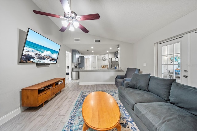 living room with vaulted ceiling, a ceiling fan, visible vents, and light wood-style floors