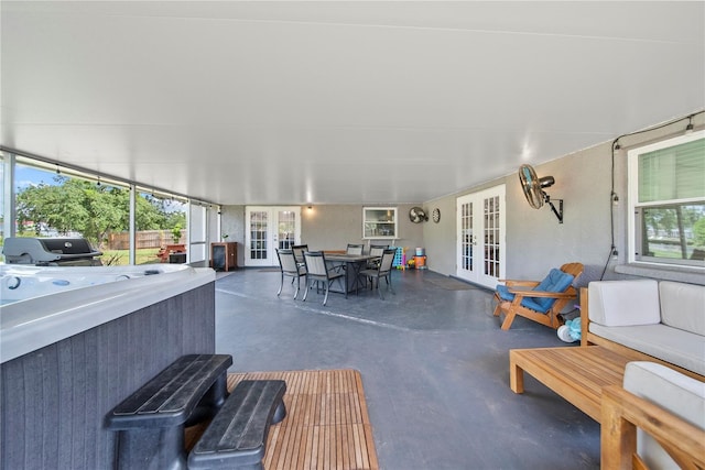 view of patio / terrace with a hot tub, french doors, fence, and outdoor dining space
