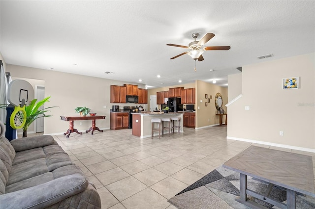 6708 Hazelnut Spice Dr, Ruskin, FL 33573 - living room featuring a ceiling fan, baseboards, visible vents, and light tile patterned flooring