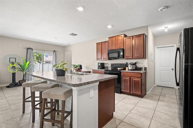 6708 Hazelnut Spice Dr, Ruskin, FL 33573 - kitchen with visible vents, a sink, light tile patterned flooring, and black appliances