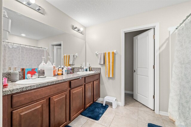 6708 Hazelnut Spice Dr, Ruskin, FL 33573 - bathroom with a sink, tile patterned floors, baseboards, and double vanity