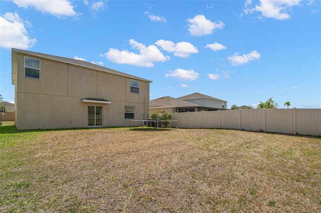 6708 Hazelnut Spice Dr, Ruskin, FL 33573 - back of property with stucco siding, fence, and a yard