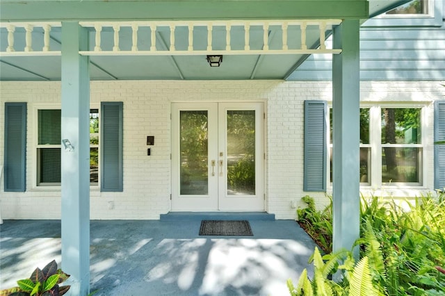 property entrance with brick siding and french doors