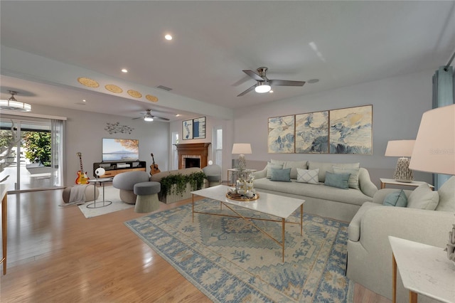 living area featuring visible vents, a brick fireplace, recessed lighting, a ceiling fan, and light wood finished floors