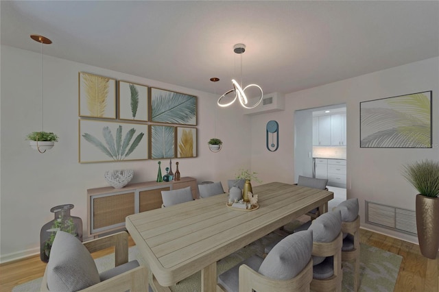 dining room with visible vents, wood finished floors, and a chandelier