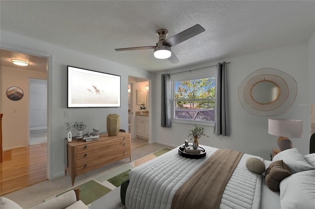 bedroom with connected bathroom, a ceiling fan, a textured ceiling, and baseboards