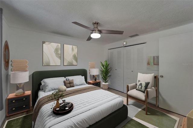 bedroom with visible vents, a textured ceiling, ceiling fan, and a closet
