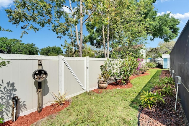 view of yard with a fenced backyard and a gate