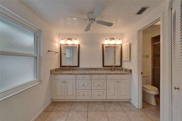 9410 Alanbrooke St, Temple Terrace, FL 33637 - full bathroom with double vanity, ceiling fan, an enclosed shower, tile patterned flooring, and a textured ceiling
