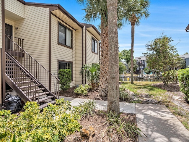 view of property exterior with a patio area and stairway