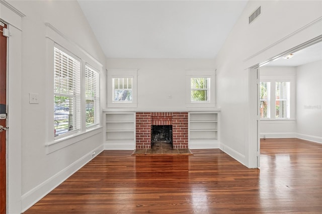 906 E Broad St, Tampa, FL 33604 - unfurnished living room featuring vaulted ceiling, wood-type flooring, and a brick fireplace