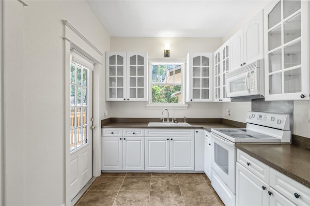906 E Broad St, Tampa, FL 33604 - kitchen with white appliances, dark countertops, healthy amount of natural light, and glass insert cabinets